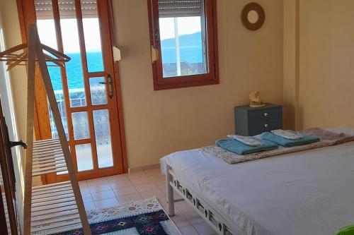 een slaapkamer met een bed en een balkon met uitzicht op de oceaan bij Stylish 3 room apartment with amazing sea views in Dikili