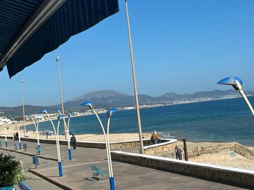 a beach with blue umbrellas and the ocean at Charmant appart à 15 minutes de la plage et du centre ville M'DICQ, TETOUAN in M'diq