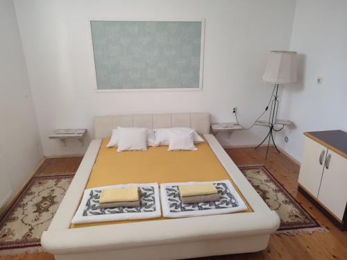 Apartman Centar في كروشيفاتس: سرير عليه وسادتين في غرفة