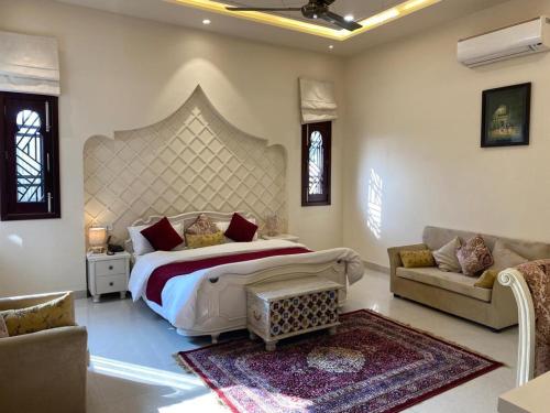 a bedroom with a large bed and a couch at Blessing Mansion, Amritsar in Amritsar