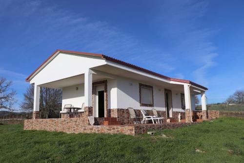 a small white house with chairs in a field at “Casa abella “ in La Magdalena