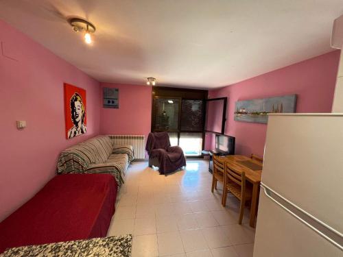 a living room with pink walls and a couch and a table at Casa Mequinenza in Mequinenza