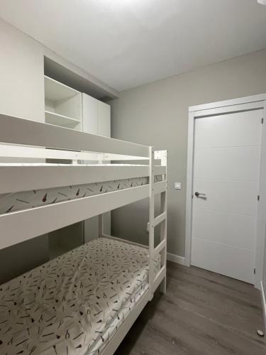 1 dormitorio con 2 literas y puerta en Centrally Located Spacious Private Apartment BuenaVista in Grao with Rooftop, en Grao de Castellón