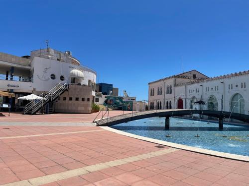 a bridge over a pool in front of a building at Centrally Located Spacious Private Apartment BuenaVista in Grao with Rooftop in Grao de Castellón