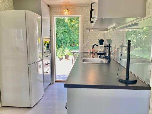 een keuken met een witte koelkast en een wastafel bij Liten stuga i Haverdal in Haverdal