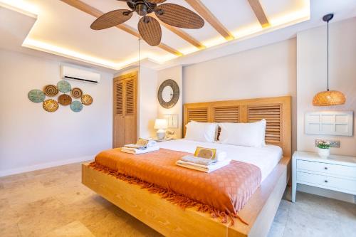 a bedroom with a large bed and a ceiling fan at Kalkan Saray Suites Hotel in Kalkan