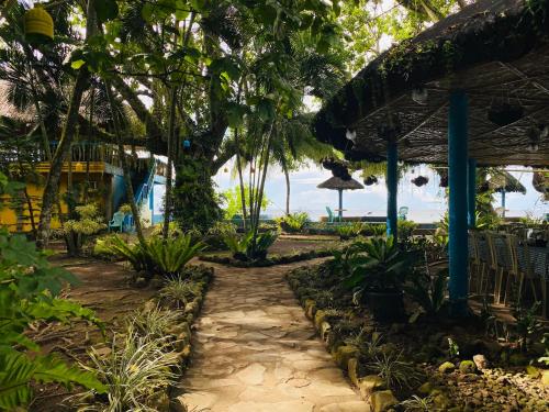 a path through a garden with an umbrella at Camiguin Island Golden Sunset Beach Club in Mambajao