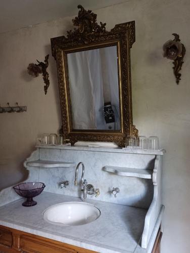 une salle de bain avec un lavabo et un miroir dans l'établissement La Maison De Marthe, à Malleval