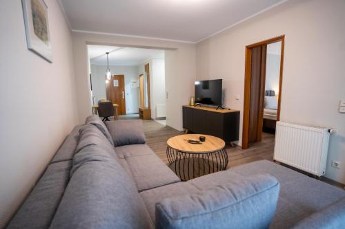 a living room with a couch and a table at Hotel CityHome am Kurpark in Bad Salzuflen