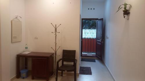 a room with a desk and a chair and a door at Wild Window - Forest View Homestay in Thekkady