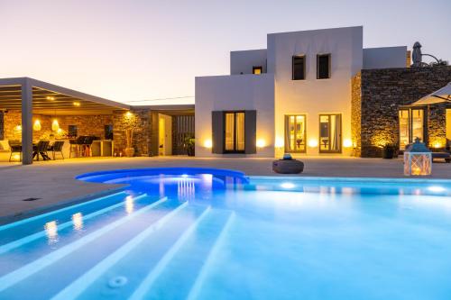a swimming pool in front of a house at Golden Bay luxury villas and suites in Chrissi Akti