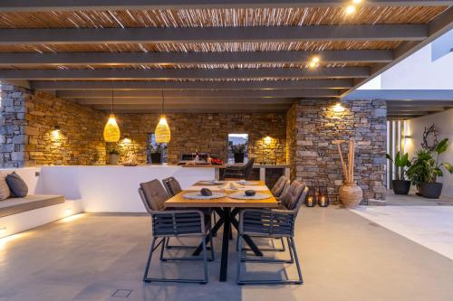 a dining room with a table and chairs at Golden Bay luxury villas and suites in Chrissi Akti