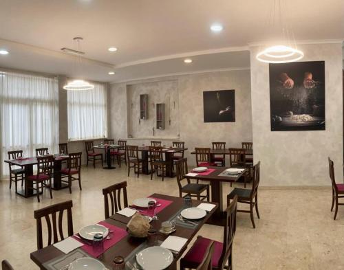 Hotel Marconi في فيوجي: غرفة طعام مع طاولات وكراسي في مطعم