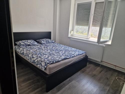 a bed in a bedroom with two windows at Apartament Gara de Nord in Bucharest