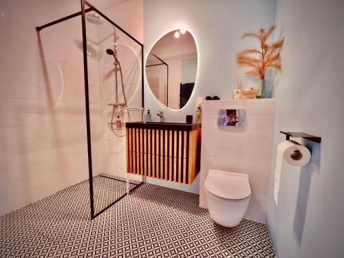 a bathroom with a shower and a toilet and a mirror at Apartament CZOS in Mrągowo