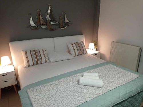 1 dormitorio con 1 cama blanca y 2 toallas en Demmy's Luxury Apartment en Orestiada