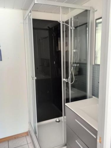 une douche avec une porte vitrée dans une salle de bain dans l'établissement Résidence la Joséphine, à Les Sables-dʼOlonne