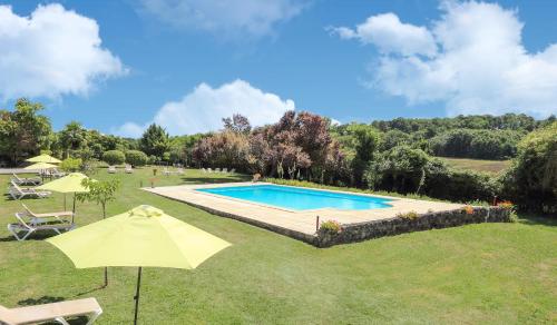 - une piscine dans une cour avec un parasol dans l'établissement Hôtel & SPA Château de La Côte - Brantôme, à Biras