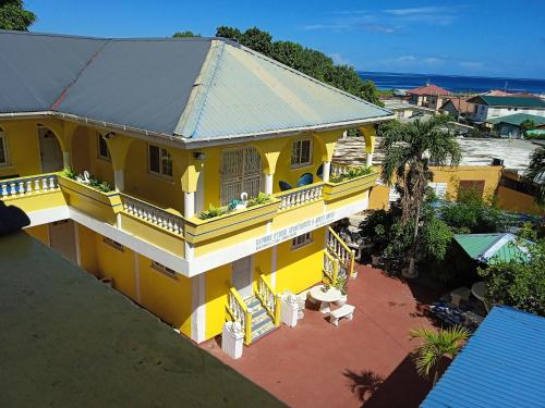 een balkon met uitzicht op een geel huis bij CAPRICE STUDIO & GUEST HOUSE in Roger