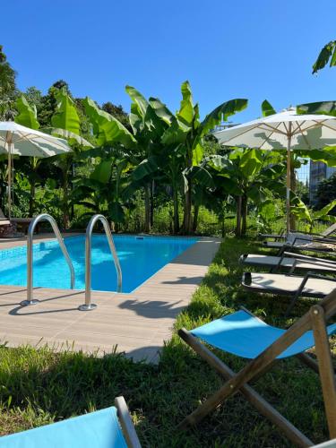 a swimming pool with lounge chairs and umbrellas at Cabo Verde Boutique Hotel in Batumi