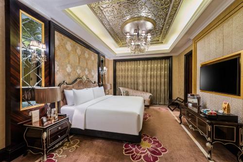 a bedroom with a white bed and a tv at Narcissus Riyadh Hotel & Spa in Riyadh
