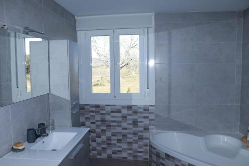 a bathroom with a tub and a sink and a window at “Casa abella “ in La Magdalena