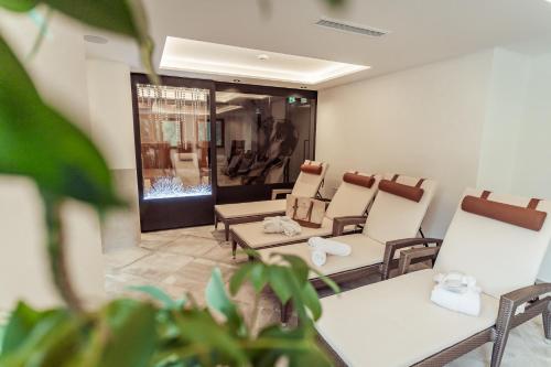 a waiting room with chairs and tables and a window at Hotel Neuhintertux 4 Sterne superior in Tux