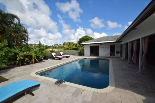 a swimming pool in the backyard of a house at Bright and cheerful 4 bedroom home pool in Boca Raton