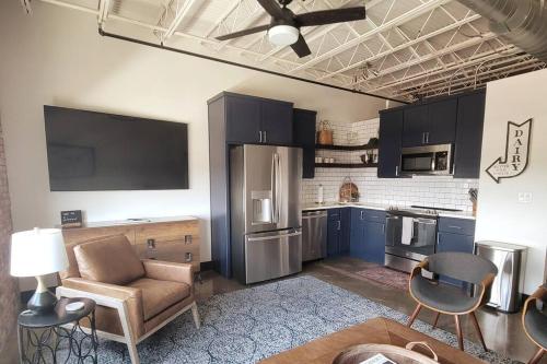 a kitchen with blue cabinets and a living room at Silo View - heart of downtown in Waco