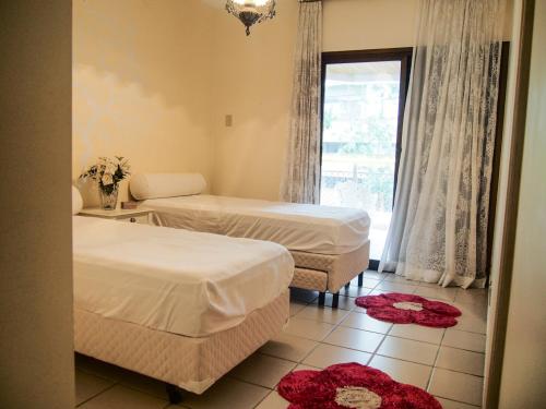 a hotel room with two beds and a window at Sorocotuba 2 - Enseada in Guarujá