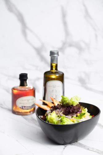 a bowl of salad and two bottles of alcohol at Kalkan Saray Suites Hotel in Kalkan