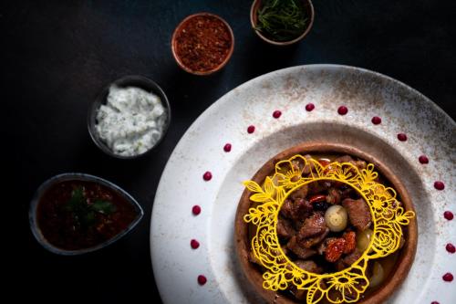 a bowl of food on a table with spices at Kalkan Saray Suites Hotel in Kalkan