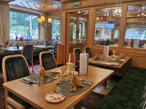 a dining room with wooden tables and chairs at Hotel Neuhintertux 4 Sterne superior in Tux