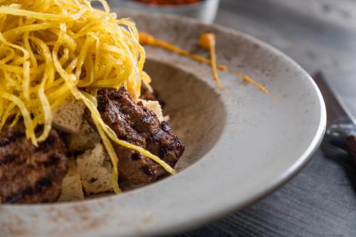 a bowl of food with cheese on top of it at Kalkan Saray Suites Hotel in Kalkan