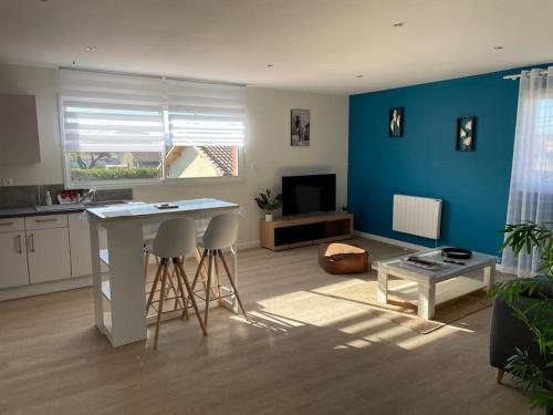 a kitchen and living room with a table and chairs at Chez ERIC in Villeneuve-du-Paréage