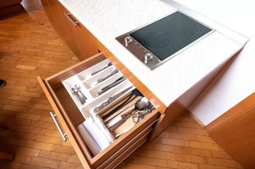 an open drawer in a kitchen with utensils at Apartmaji in sobe RaMar in Straža
