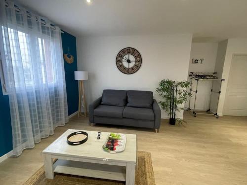 a living room with a couch and a table at Chez ERIC in Villeneuve-du-Paréage