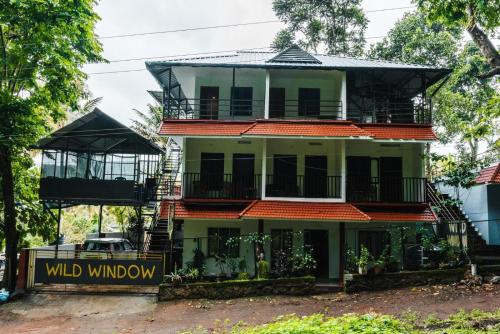 a building with a wild window sign in front of it at Wild Window - Forest View Homestay in Thekkady
