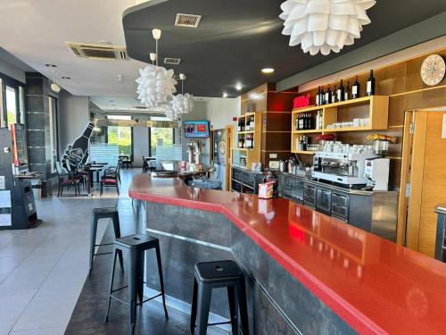 un restaurante con barra roja y taburetes en HOSTAL RESTAURANTE AQUA, en Ourense