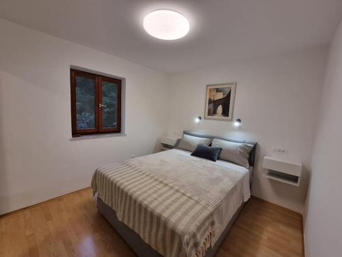 1 dormitorio con 1 cama en una habitación blanca en Apartman Flavio, en Skrbčići