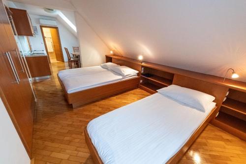 a room with two beds and a refrigerator in it at Apartmaji in sobe RaMar in Straža