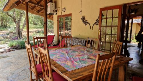 a dining room with a wooden table and chairs at Bona Intaba Game Lodge in Hoedspruit