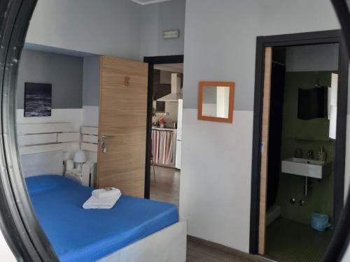 1 dormitorio con cama azul y espejo en My Room Roma, en Lido di Ostia