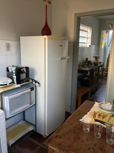uma cozinha com um frigorífico branco e uma mesa em Apto Hiper centro diamantina em Diamantina