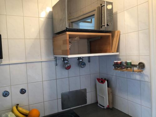 uma pequena cozinha com um lavatório e um micro-ondas em Top-Appartement direkt an der Kampenwandbahn em Aschau im Chiemgau