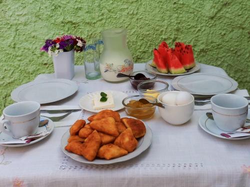 a table with plates of food and cups on it at Villa Oasis in Berat