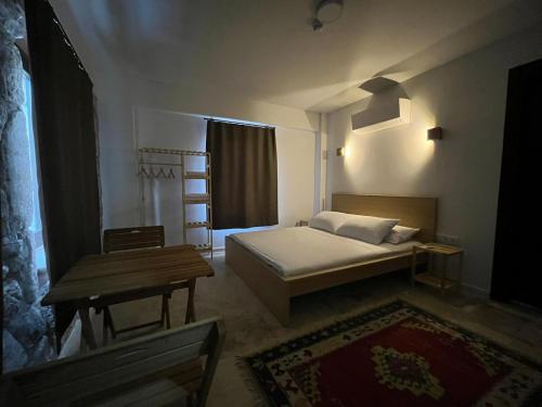 a bedroom with a bed and a table and a window at AGON Ephesus in Selcuk