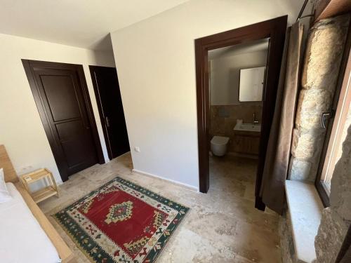 a room with two doors and a bathroom with a rug at AGON Ephesus in Selcuk