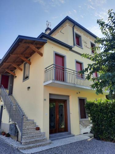 a white house with red windows and stairs at VillaSveva in Sernaglia della Battaglia