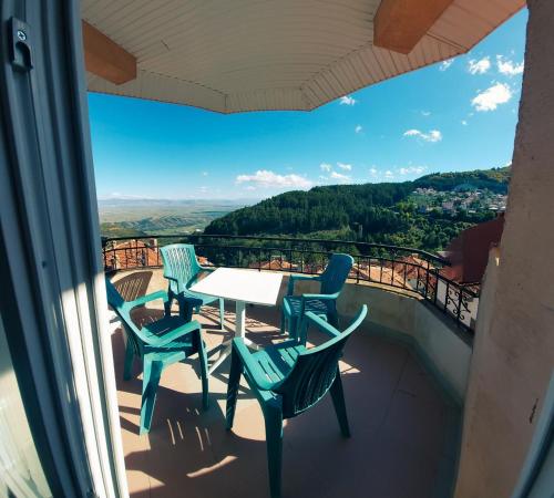 a table and chairs on a balcony with a view at Vila Papu in Kruševo